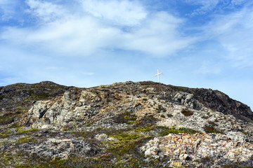 Fototapeta na wymiar Cross on rocky hill with blue sky
