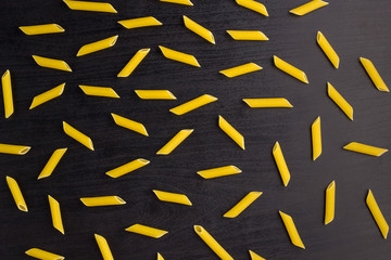 Pattern of A pile of penne pasta on black background