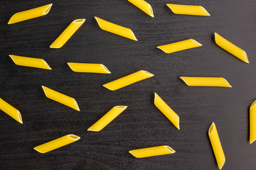 Pattern of A pile of penne pasta on black background