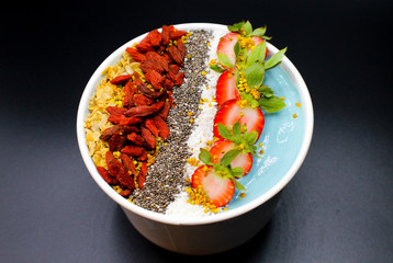 blue smoothie bowl with seeds, fruit, goji berries