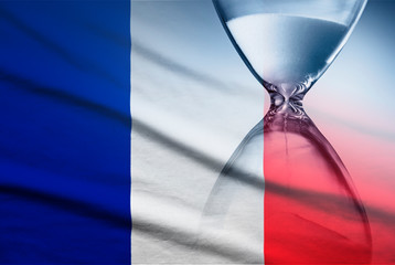 Flag of France with superimposed hourglass conceptual of deadlines