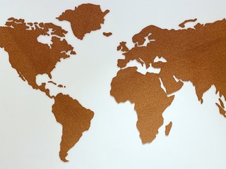 Cork plain world map shape on white wall 