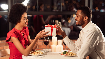 Man Giving Gift To Girlfriend Celebrating Valentine In Restaurant, Panorama