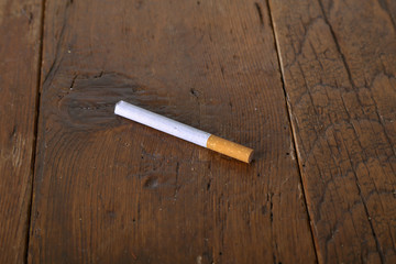 Filter cigarette lies on a wooden table