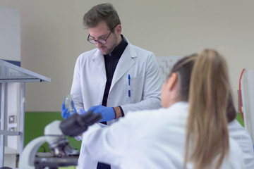 Group of  Laboratory scientists working at lab with test tubes, test or research in clinical laboratory.Science, chemistry, biology, medicine and people concept.