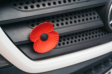 Close up of a Car decorated with a red symbolic poppy flower as a symbol of Remembrance Day.