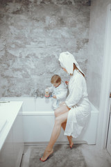 Family in a bathroom. Beautiful mother with little son