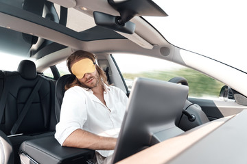 Man taking nap in car, wearing in sleeping mask
