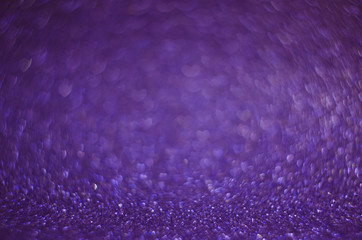 Obraz premium Abstract New Year violet bokeh background with shining defocus sparkles. Blurred glitters shimmering dust macro close up, copy space for text logo