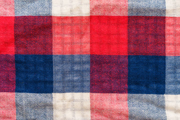 Plaid material texture. Red, blue and white cage clothes background