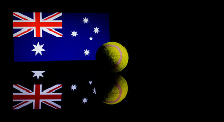 Yellow Tennis Ball on black mirror with Australian Flag in the background