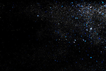 Texture of golden and blue glitter on black background.