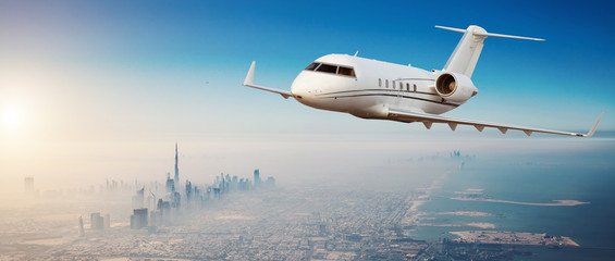 Private jet plane flying above Dubai city