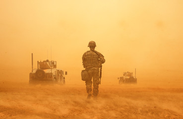 Military forces between storm & dust in the desert in battlefield