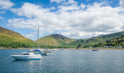 Fototapeta na wymiar Lochranza bay with boats at anchor. Arran island, sailing trip in Scotland.