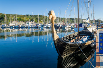 Old drakkar - historic viking's boat at Tarbert marina. Hebrides, Scotland.