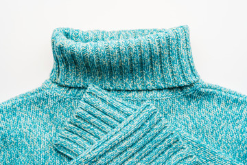 Blue turquoise sweater with a high collar on a white background.