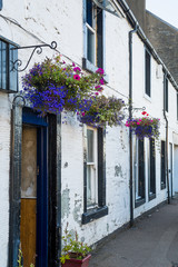 Tarbert old town street, traditonal houses decorated with flowers. Hebrides islands, Scotland.