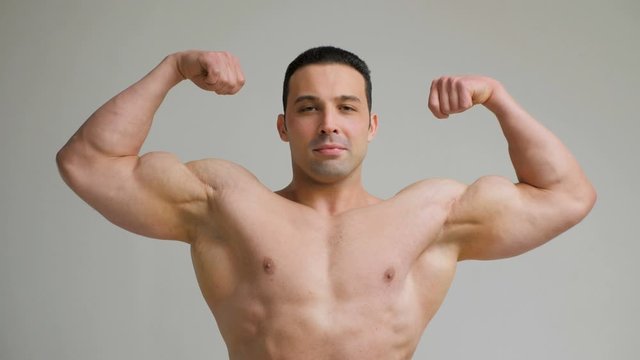 Handsome bodybuilder posing on white background. Fitness muscular body