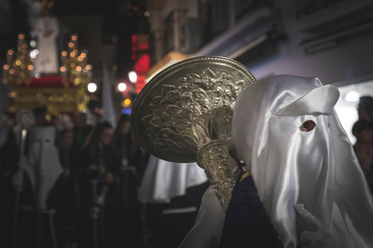 Jesus Christ statue in a holy week procession in Marbella with nazarenes in the street