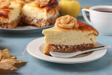Cheesecake with apples and cup of coffee located on a light blue background, decorated with roses from apples, Horizontal orientation