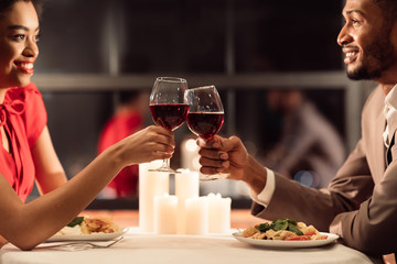 African American Spouses Having Romantic Date Clinking Glasses In Restaurant