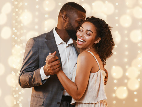 Beautiful happy black couple dancing in modern restaurant - Powered by Adobe