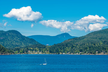 Fototapeta na wymiar View over inlet, ocean and island with boat and mountains in beautiful British Columbia. Canada.
