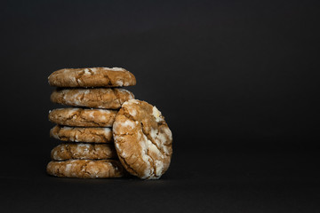 Stack of brown cinnamon cookies on dark background