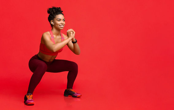 Happy black girl enjoying working out over red background