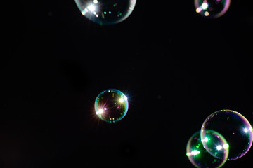 Round soap bubbles on a dark background