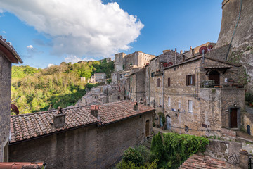 Panoramic view of small vilage in Italy with red brick houses and towers and nature in Sovana Sorano with beautiful sky with clouds in Lazio region Viterbo province in Italy