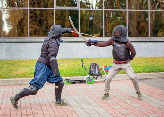 Two armed men lead a sword fight, a medieval fight, at a fun medieval tournament. Sports...