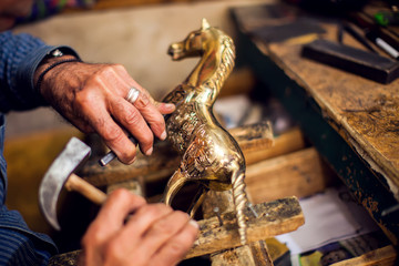 A man making embassed figure. Art and handwork industry