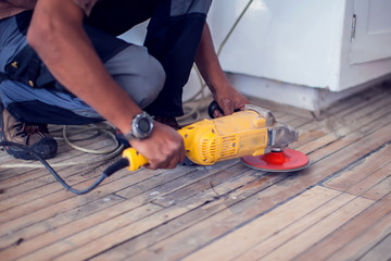 Handyman sanding floor. Repairs and renovation work
