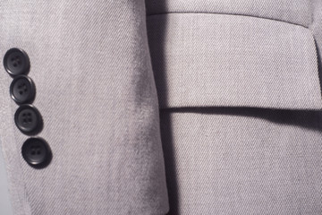 closeup of a sleeve with buttons of a gray female jacket, business girl