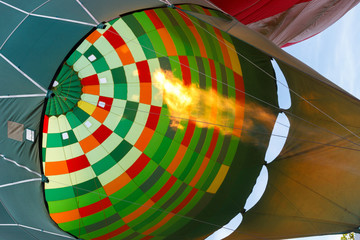 A colourful hot air balloon is inflated with hot gas before taking off