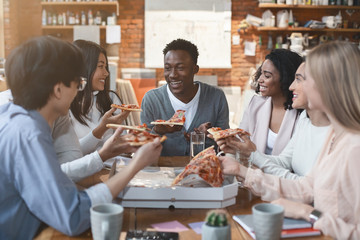 Happy people eating lunch at coworking office during break