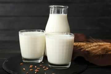 Glasses and bottle of tasty on dark table