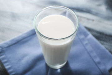 Glass of tasty milk on wooden table