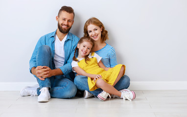 happy family mother father and child  near an empty brick wall.