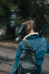 Fototapeta premium woman with punk style, with gas mask, backpack and double barrel shotgun. post-apocalyptic, military and airsoft war games concept.