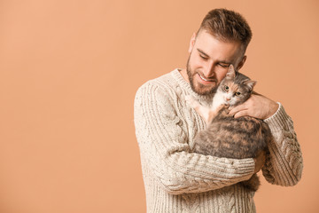 Man with cute cat on color background