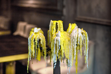 melted burnt candles with wax drips on a candelabrum in the interior of a romantic restaurant, close up nobody.