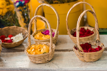 Fototapeta na wymiar Colored roses petals in handmade decorative baskets