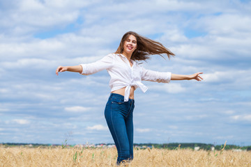 Young brunette woman in white shirt and blue jeans shorts