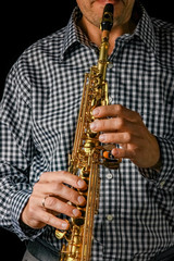 Fototapeta premium soprano saxophone in hands on a black background