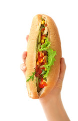 Female hand with tasty hot dog on light background