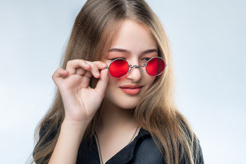 Beautiful young girl in sunglasses with mirror glasses in the studio