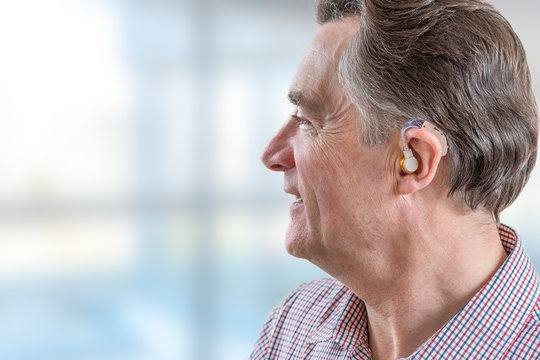 head of a senior man with hearing aid in his ear
